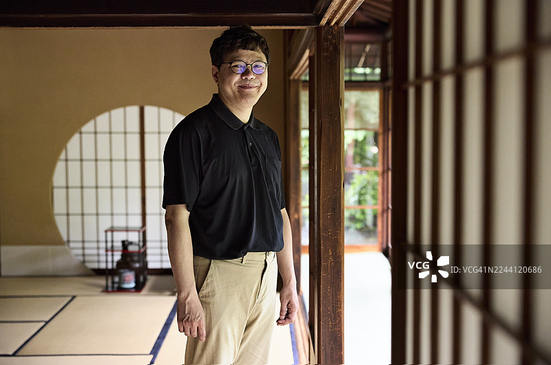 微笑的男人站在茶室入口附近图片素材
