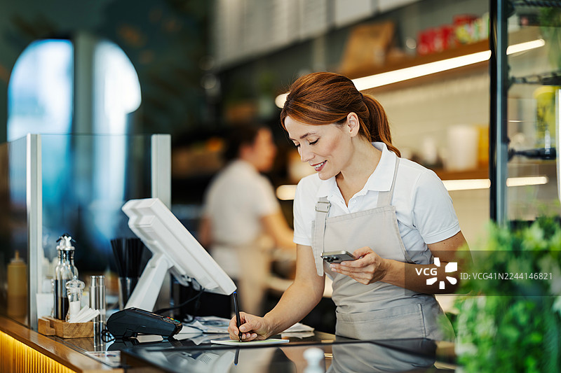 服务员在咖啡馆微笑地为顾客点餐图片素材
