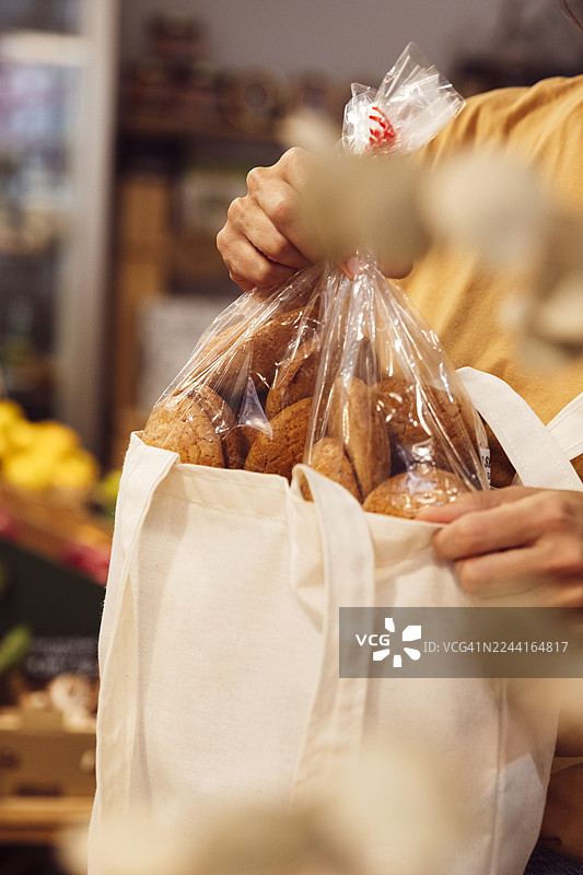 一位女士在有机零浪费超市用可重复使用的布袋大量购买蔬菜，留有复制空间图片素材