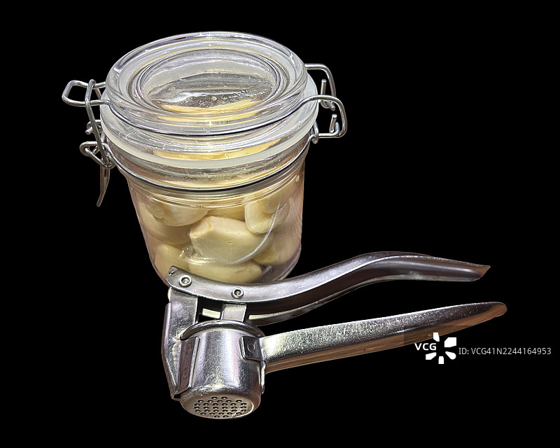 罐装保存的蒜头和压蒜器图片素材