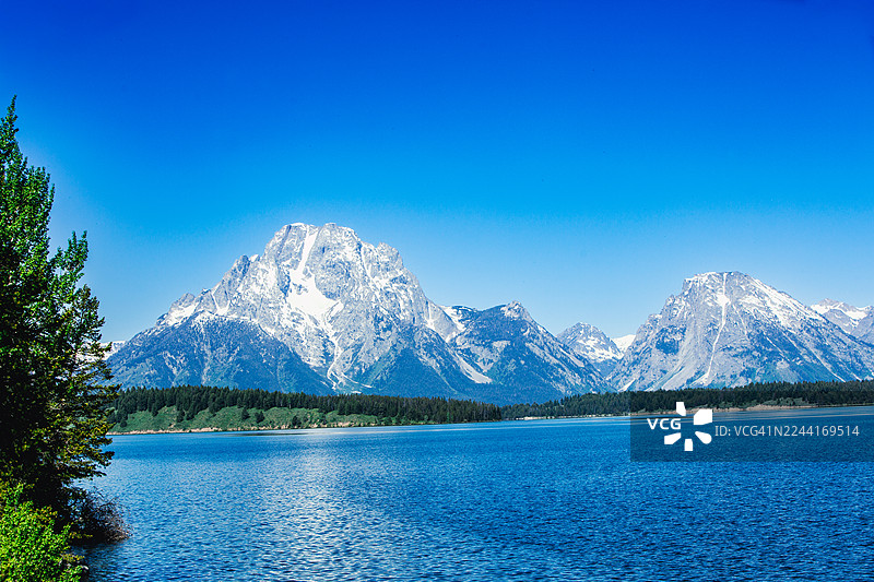 大提顿峰在蓝色高山湖上方拔地而起图片素材