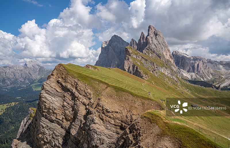 意大利多洛米蒂山脉塞切达山脊的全景，戏剧性的山峰和郁郁葱葱的绿色斜坡在多云的天空下，意大利图片素材