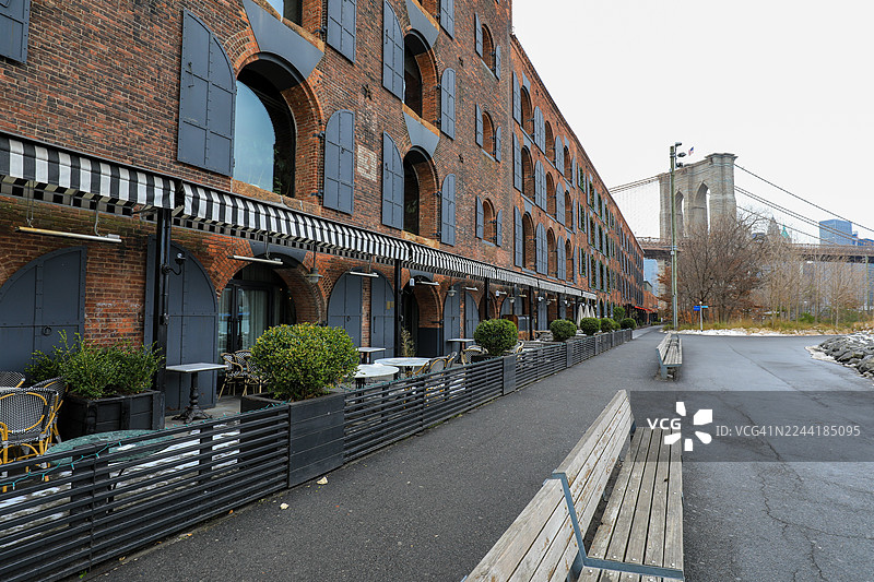 美国纽约布鲁克林，历史悠久的砖砌建筑旁的一条空旷街道和布鲁克林大桥图片素材