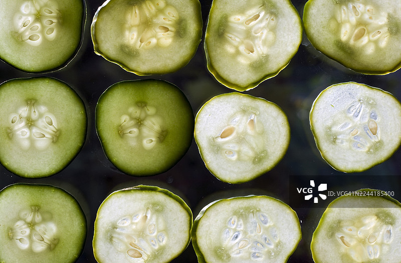 新鲜黄瓜切片的特写全景镜头，展示了其错综复杂的细节和鲜艳的绿色。图片素材