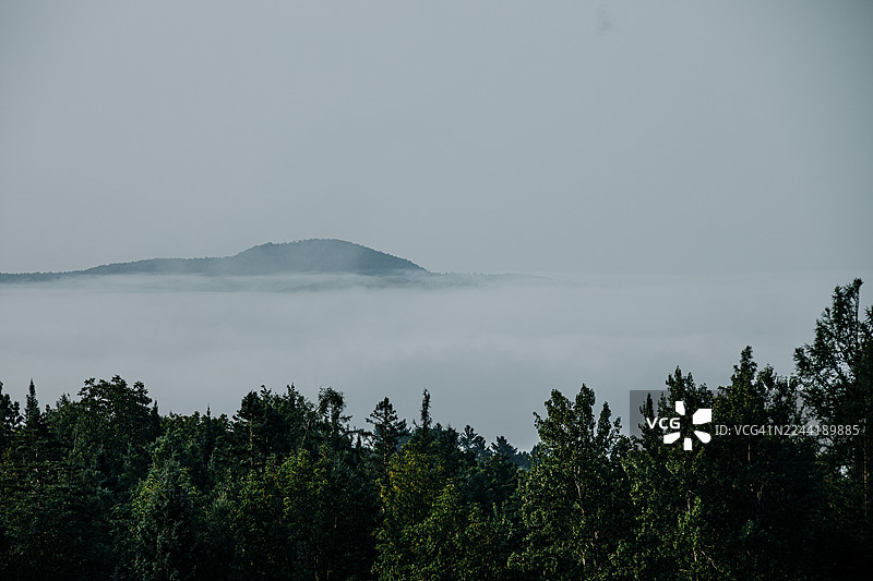 云雾缭绕的早晨，远眺连绵的森林山脉，天空布满云彩，美国东伯克图片素材