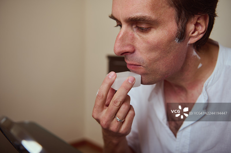 特写镜头下，男人在自我护理时刻涂抹润唇膏图片素材