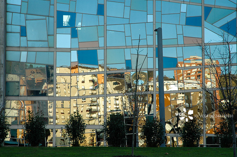 西班牙毕尔巴鄂的现代建筑，其反光玻璃幕墙映照出扭曲的城市景象图片素材
