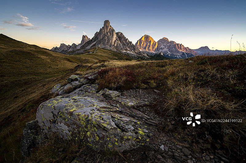 夕阳金色光辉照耀下的壮丽山脉，拥有崎岖的山峰和广阔的自然景观，意大利圣维托迪卡多雷，贾乌山口图片素材