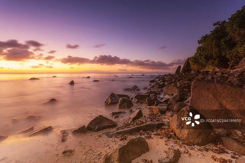 斐济马洛洛岛托科里基岛，海边岩石上壮丽的日落，天空鲜艳，海洋平静图片素材