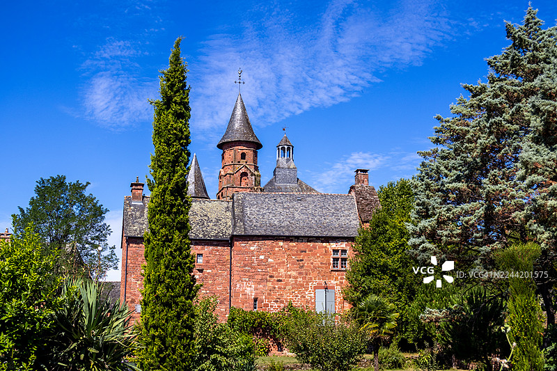 从低角度仰视科隆日红教堂，背景是晴朗的蓝天，法国，康塔尔省图片素材