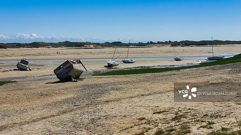 退潮时，在晴朗蓝天下，船只搁浅在广阔的沙滩上，法国，博尔巴伊图片素材