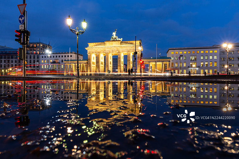 德国首都柏林，在蓝色时刻的勃兰登堡门及其在水坑中的倒影图片素材