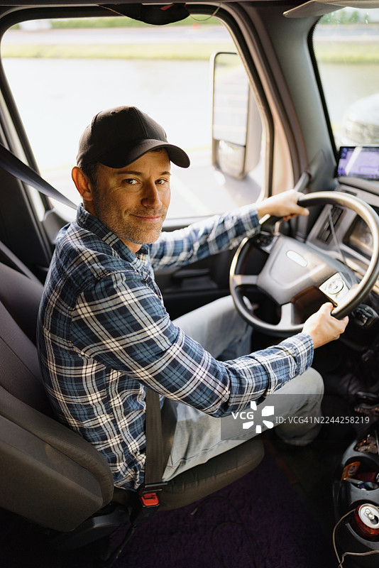 卡车司机微笑着握着方向盘图片素材