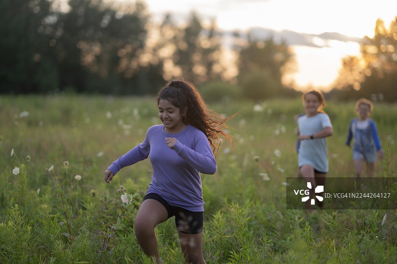 夕阳下，一群快乐的孩子们在田野里与朋友们奔跑，享受自由的时光。图片素材