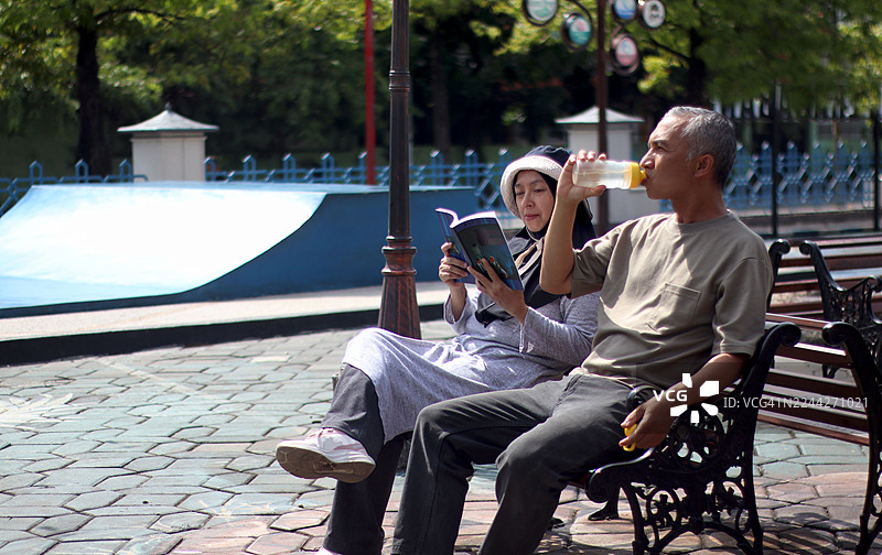 情侣在公园长椅上放松图片素材