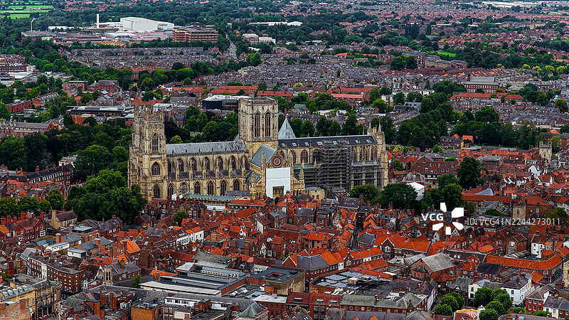 英格兰北部约克市约克大教堂的鸟瞰图，周围环绕着历史悠久的红色屋顶和绿色树木，体现了旅行和文化设计的遗产与建筑概念图片素材