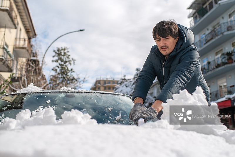 大雪过后，一名男子正在清洗他的汽车图片素材