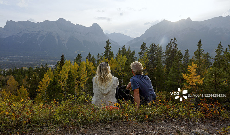 恩爱的老年夫妇在落基山脉的山间草地上放松图片素材
