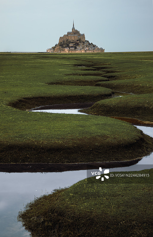 法国诺曼底，圣米歇尔山修道院矗立在盐沼之上，蜿蜒的水道穿行其间图片素材