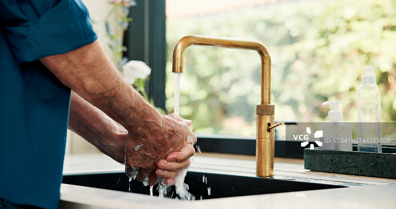 洗手，流水和厨房水龙头，注重家庭卫生、健康和肌肤清洁。房屋、成熟男性、细菌或病菌，以及消毒、自我护理和肥皂冲洗。图片素材