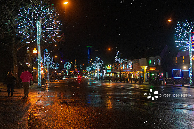 夜色中，一男一女在圣诞节的城市里散步图片素材
