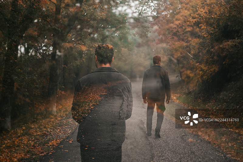 一个人在秋日小径上行走，双重曝光效果象征着回忆图片素材