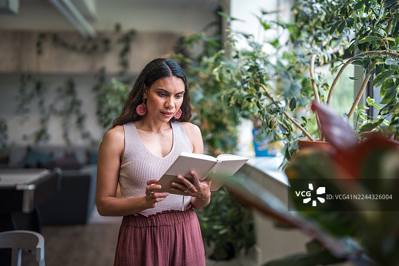 自信的澳大利亚原住民女商人正在明亮的办公室里查阅笔记图片素材
