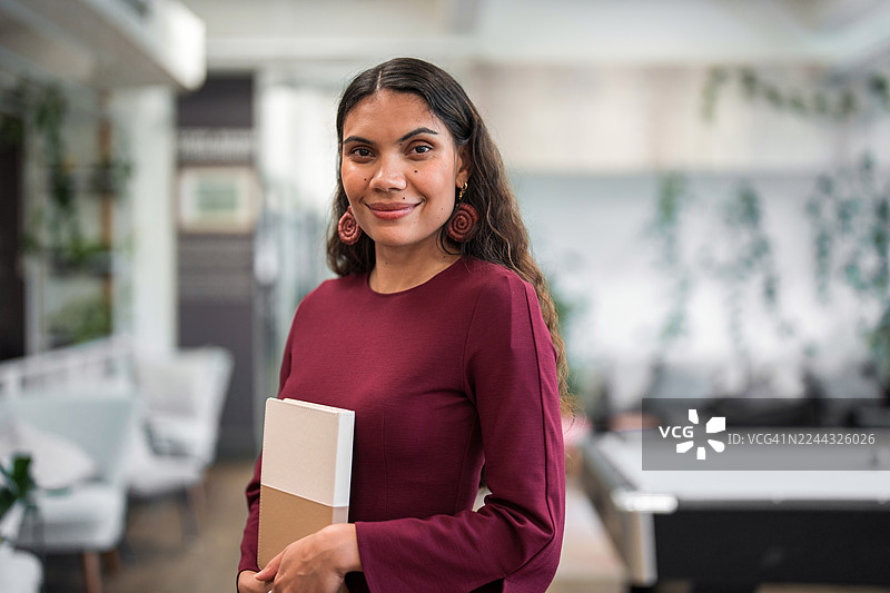 自信的年轻原住民女商人正在办公室工作图片素材