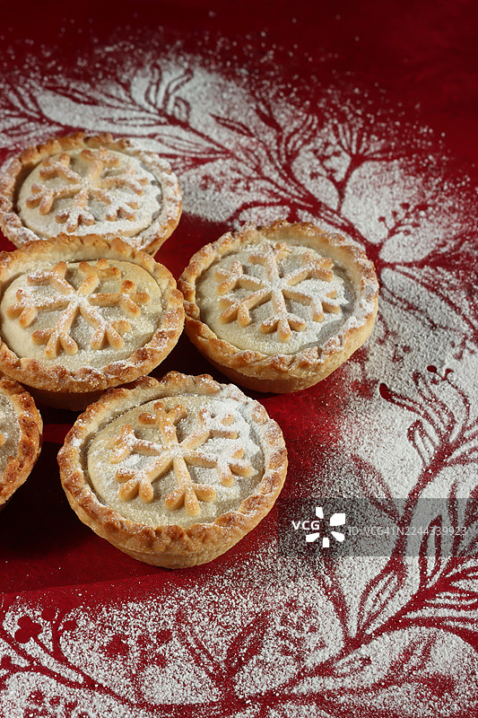 圣诞肉馅饼，精致的雪花酥皮图案，撒上糖粉 / 节日挞，节日甜点装饰图片素材