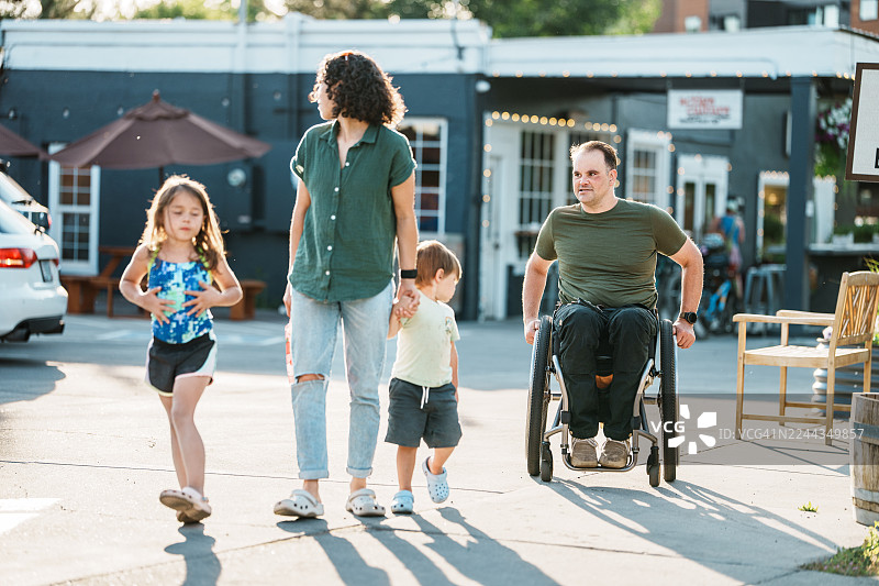 一家人在阳光明媚的下午散步，享受悠闲时光图片素材