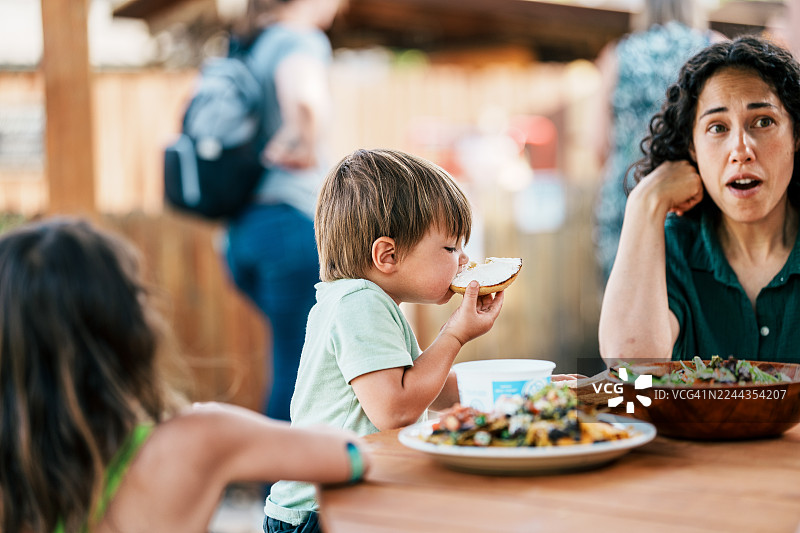 小男孩在餐厅与家人户外用餐图片素材