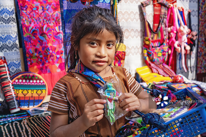 危地马拉集市上持有手工艺品的原住民女孩图片素材