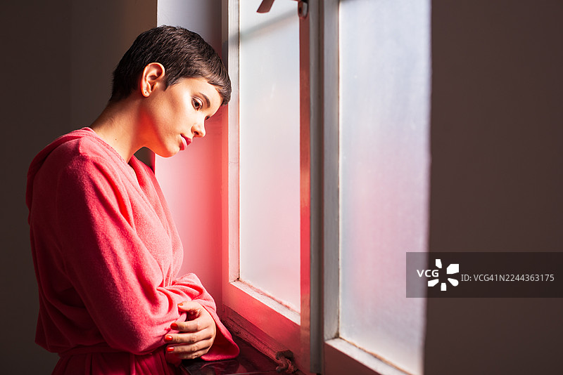 患有癌症的年轻女子正透过医院的窗户向外望去图片素材