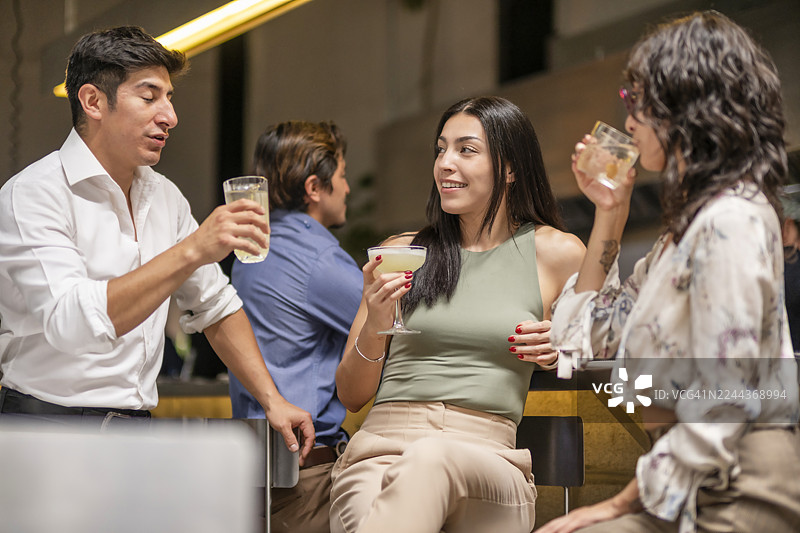 一群年轻的专业人士正在与同事开会，并享用饮品。图片素材