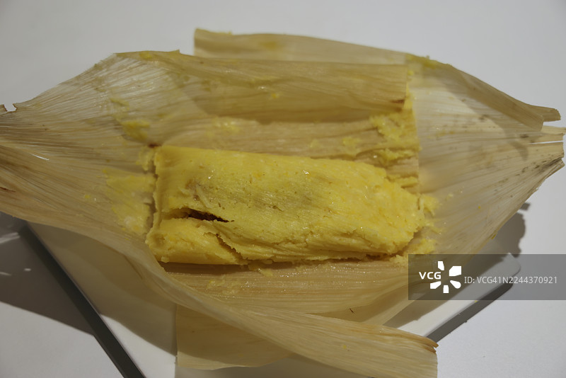 盘子里的奶酪和番石榴玉米蛋糕（一种传统的哥伦比亚玉米蛋糕，内填奶酪和番石榴酱，用玉米叶包裹蒸煮而成）图片素材