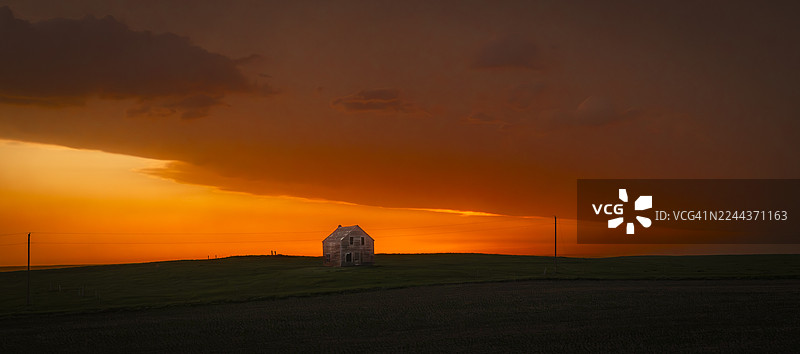 大平原上日落时分戏剧性的橙色天空与火车轨道图片素材