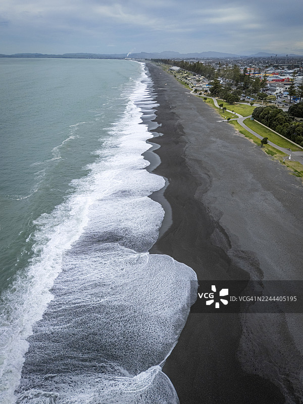 海浪拍打鹅卵石海滩上的沿海小镇图片素材