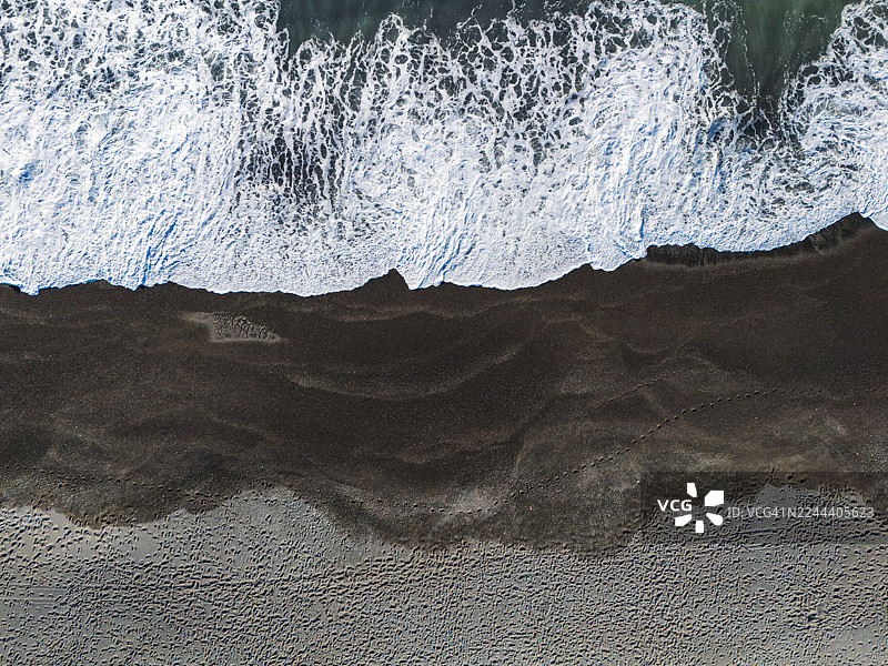 空中俯瞰鹅卵石海滩上的海浪图片素材