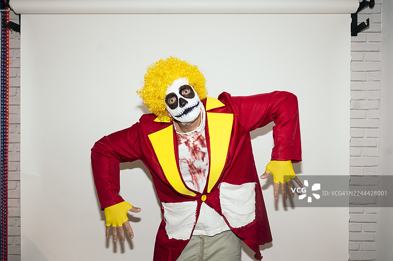 万圣节，一个打扮成恐怖小丑骷髅服装的男人图片素材