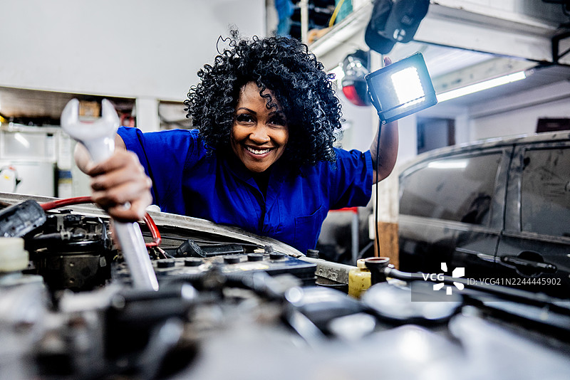 修车行的女机械师正在修理汽车图片素材