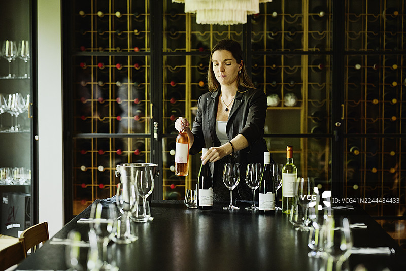 中景镜头，女性侍酒师为品酒做准备图片素材