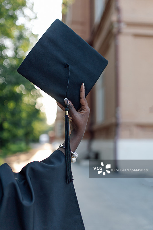 毕业生在户外仪式上抛帽庆祝成就图片素材