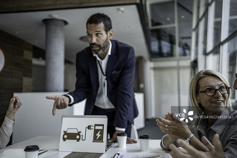 商务人士正在讨论电动汽车基础设施和充电解决方案图片素材