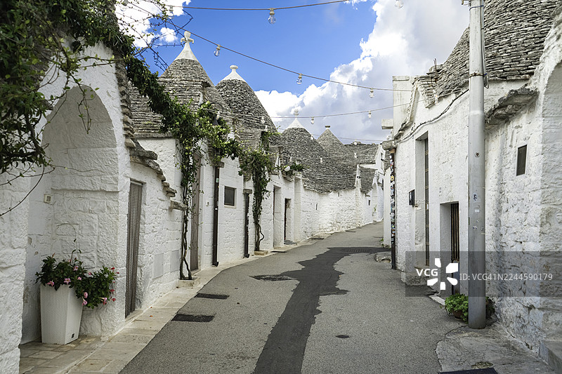 意大利阿尔贝罗贝洛——普利亚地区历史悠久的联合国教科文组织世界遗产村落，鹅卵石街道旁矗立着传统的特鲁利房屋，拥有标志性的锥形石屋顶，展示了意大利文化、建筑以及欧洲热门旅游目的地。图片素材