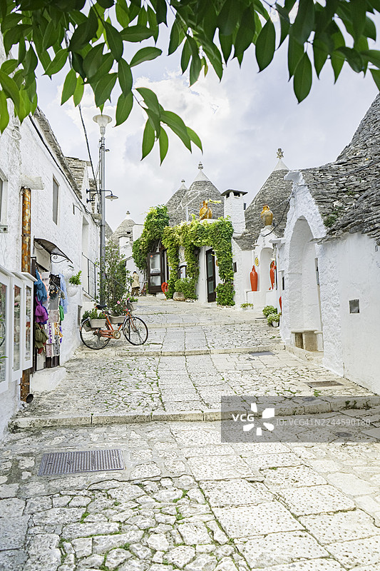 意大利阿尔贝罗贝洛——普利亚地区历史悠久的联合国教科文组织世界遗产村落，鹅卵石街道两旁是拥有标志性锥形石屋顶的特鲁利传统房屋，展示了意大利的文化、建筑，是欧洲热门旅游目的地。图片素材