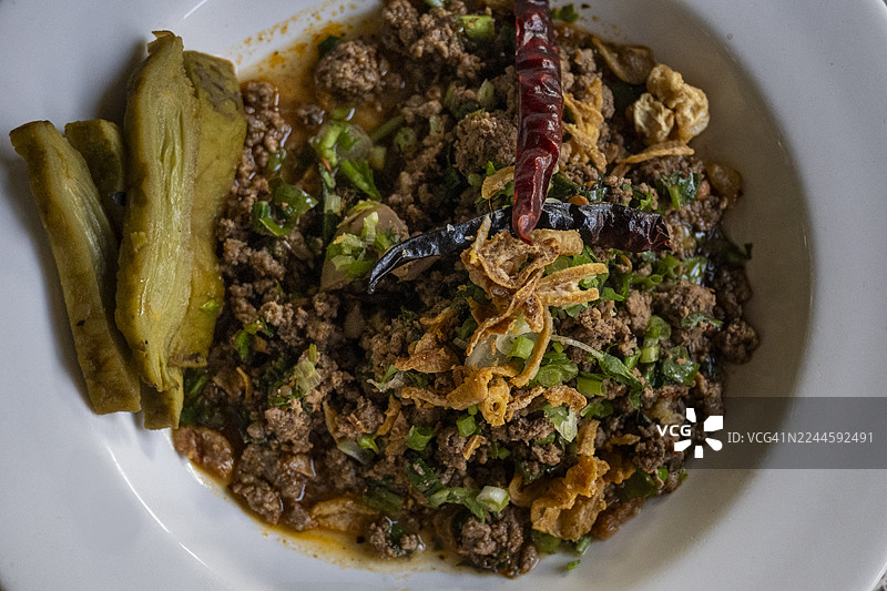 俯视泰北香辣猪肉碎沙拉（Larb Moo Kua），用香草、辣椒和烤米干炒而成，香气浓郁。图片素材