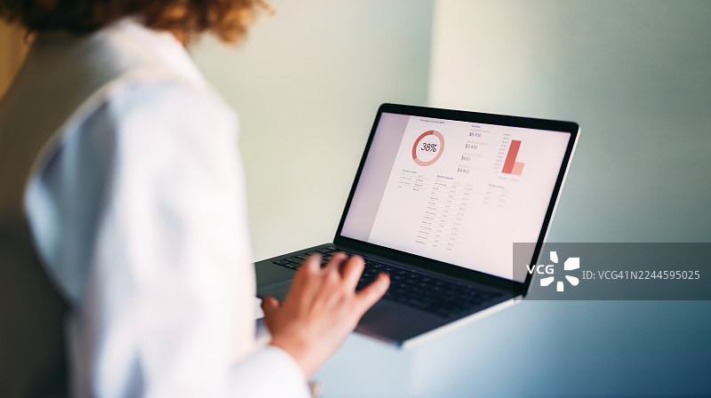 用户专注地分析带有数据图表和财务统计的笔记本电脑仪表板图片素材