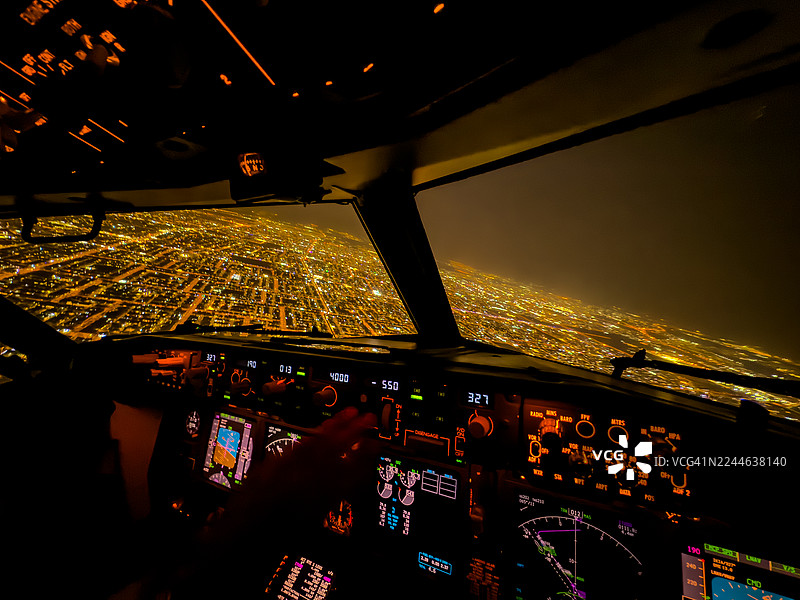 梦境飞行——夜晚城市上空发光的客机驾驶舱图片素材