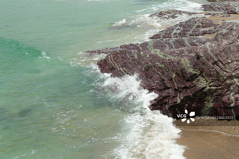 海浪拍打着色彩斑斓的石板岩图片素材