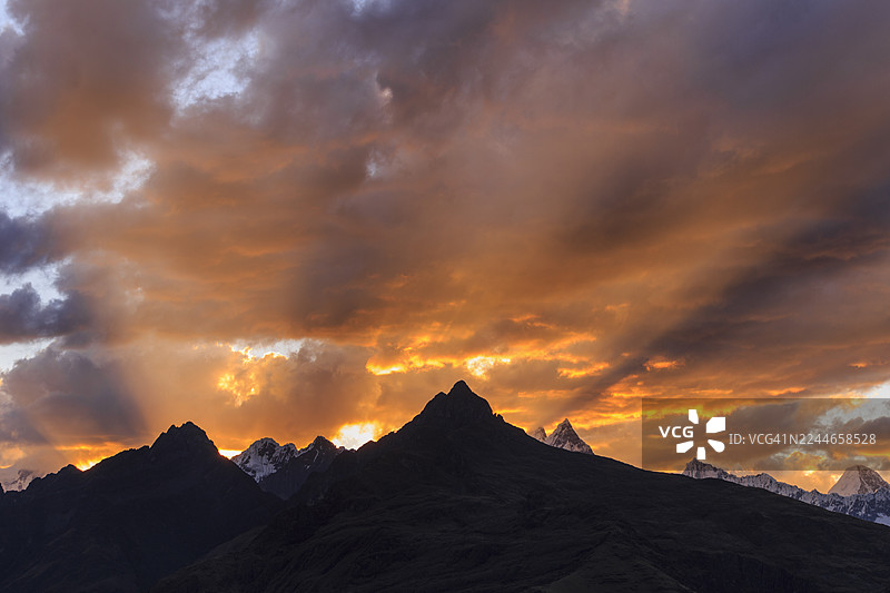 火焰般的夕阳云彩映衬着山峦剪影图片素材